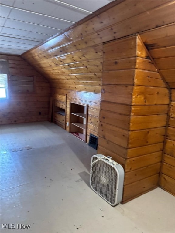 additional living space with lofted ceiling and wooden walls