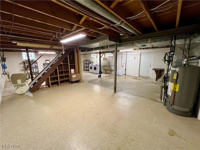 below grade area with stairs, water heater, and washer and clothes dryer