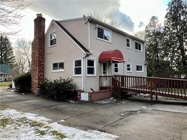 rear view of property featuring a chimney