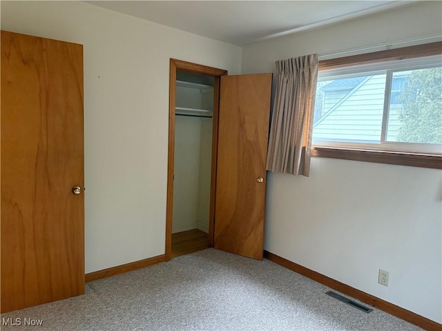 unfurnished bedroom featuring a closet, carpet flooring, visible vents, and baseboards