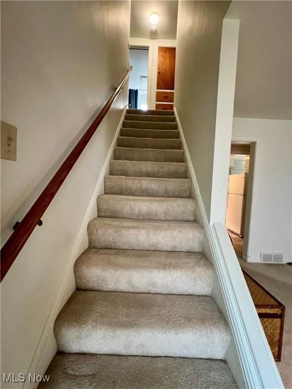 stairs with visible vents and carpet flooring