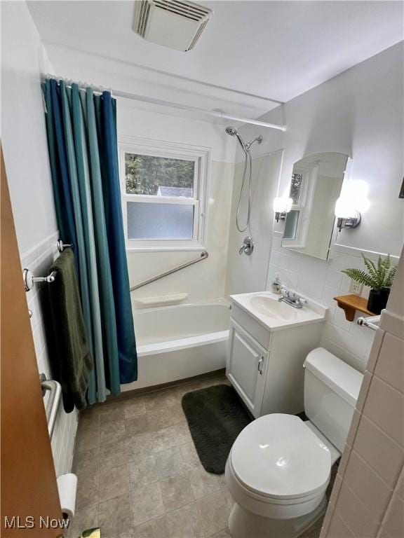 full bathroom featuring shower / tub combo with curtain, tile walls, visible vents, toilet, and vanity