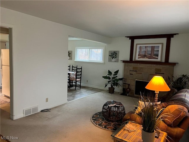 living area featuring baseboards, visible vents, a fireplace, and carpet flooring