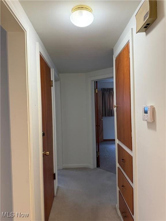 corridor with light carpet and baseboards