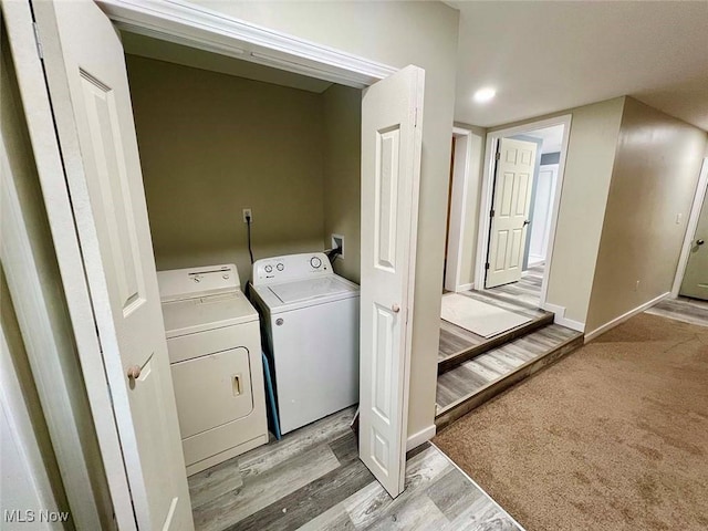 laundry area featuring laundry area, light wood-type flooring, washing machine and clothes dryer, and baseboards