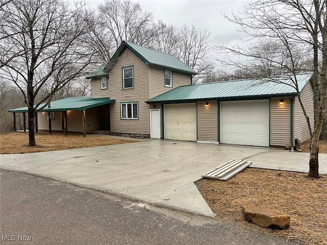 view of front of home featuring an attached garage, driveway, and metal roof