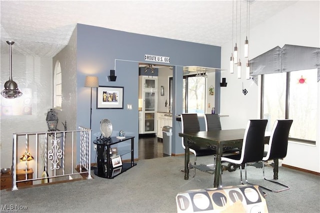 dining area featuring a textured ceiling, carpet, and baseboards