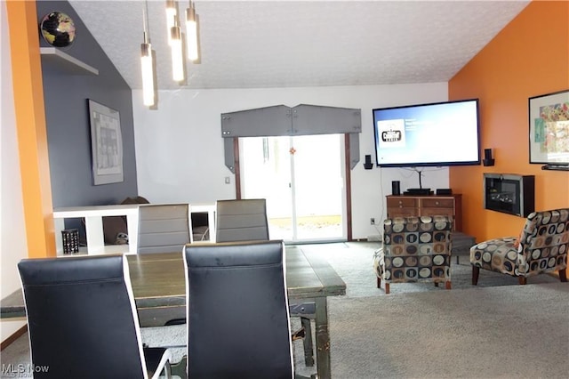 dining area featuring a textured ceiling, carpet flooring, and lofted ceiling