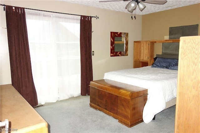 bedroom featuring a textured ceiling, ceiling fan, and carpet flooring