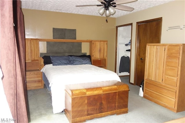 carpeted bedroom featuring a textured ceiling and ceiling fan