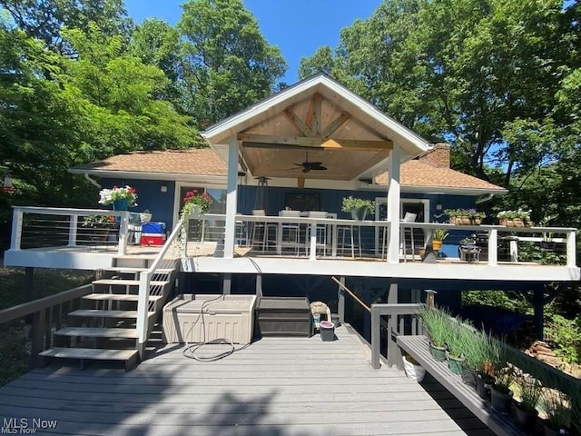 back of property with a ceiling fan, a chimney, stairway, and a wooden deck