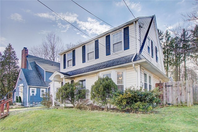 view of front of home with a front yard and fence