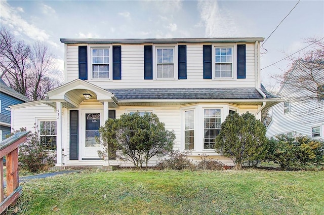 view of front of property featuring a front lawn and a shingled roof