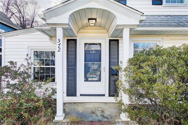 property entrance with a shingled roof