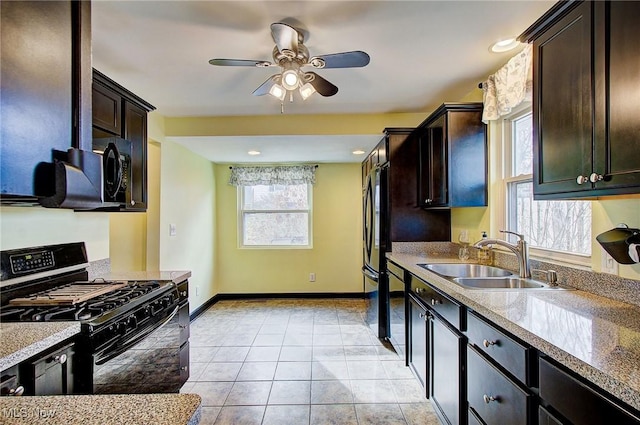 kitchen with light tile patterned floors, black appliances, a sink, and dark brown cabinetry