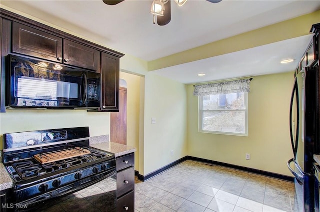 kitchen with dark brown cabinetry, baseboards, a ceiling fan, black appliances, and light tile patterned flooring