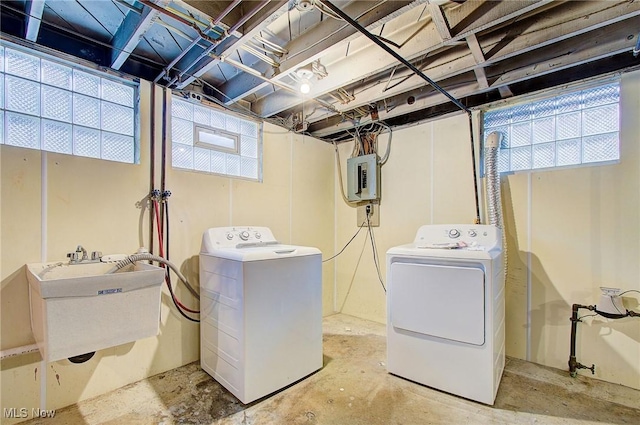 washroom featuring a sink, laundry area, electric panel, and washer and dryer