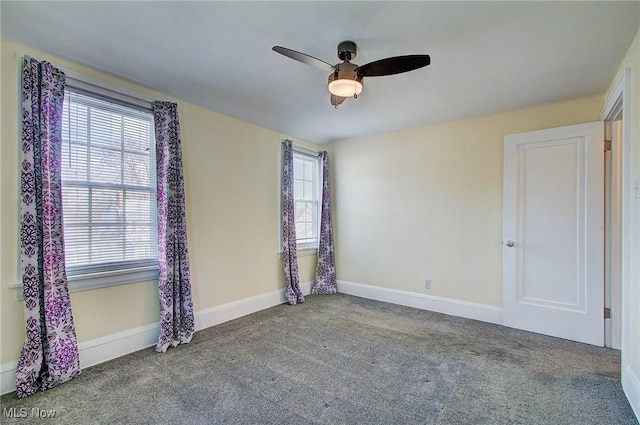 carpeted empty room with a ceiling fan, baseboards, and a wealth of natural light