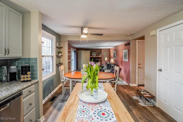 dining area with visible vents, baseboards, dark wood-style floors, ceiling fan, and a textured ceiling