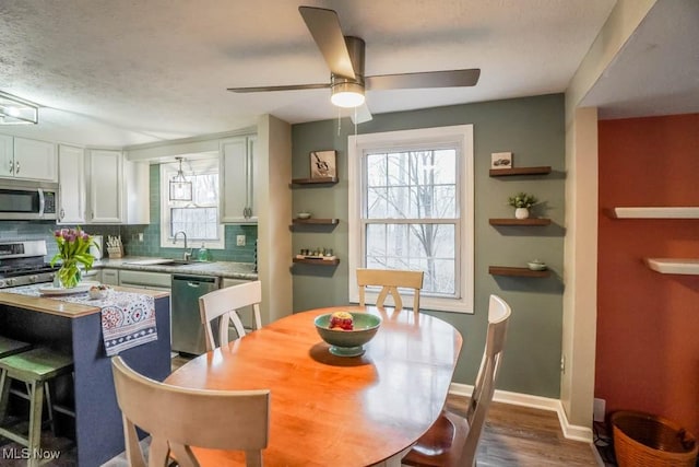 dining area with plenty of natural light, baseboards, ceiling fan, and dark wood-type flooring