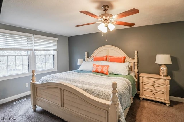 carpeted bedroom featuring a ceiling fan, visible vents, and baseboards