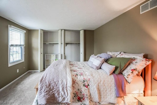 carpeted bedroom featuring visible vents and baseboards