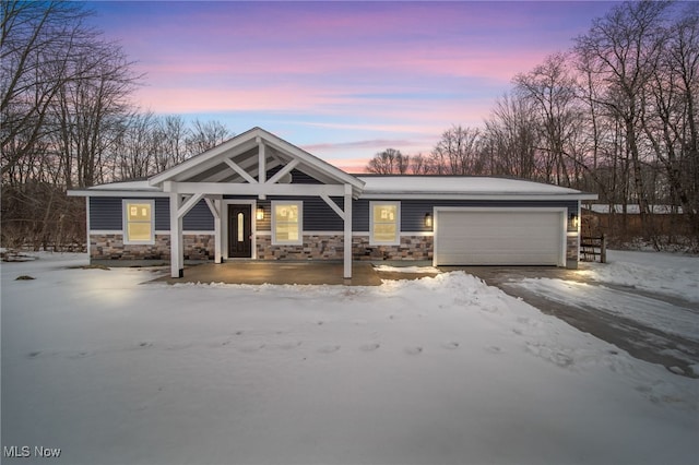 view of front of property featuring an attached garage and stone siding