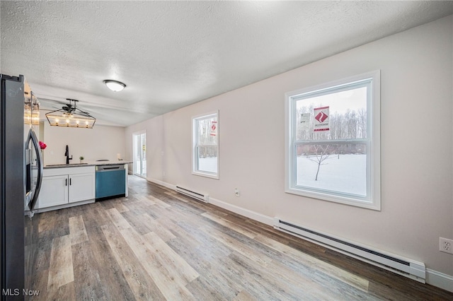 kitchen featuring dishwashing machine, a baseboard radiator, a sink, and stainless steel fridge with ice dispenser