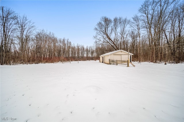 yard layered in snow featuring an outbuilding