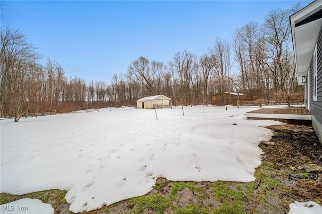 yard layered in snow featuring an outbuilding