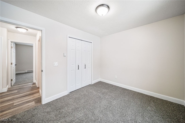 unfurnished bedroom featuring carpet, a closet, baseboards, and a textured ceiling