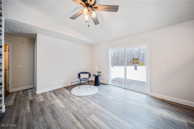 unfurnished room with vaulted ceiling, a textured ceiling, baseboards, and wood finished floors