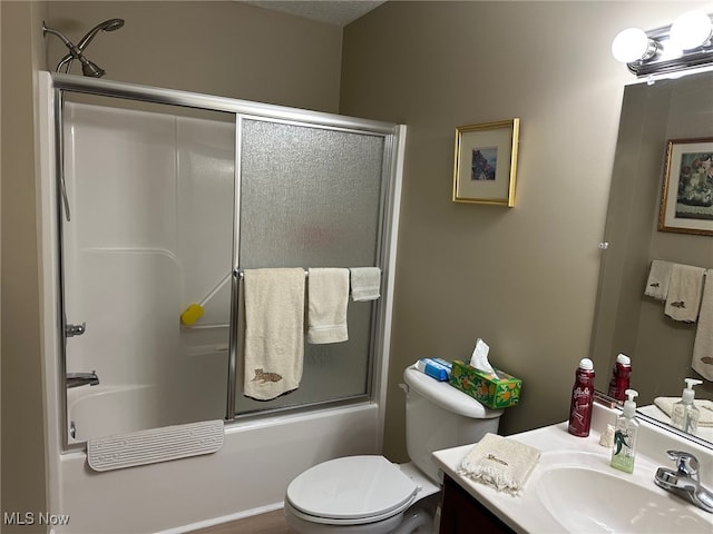 bathroom featuring toilet, bath / shower combo with glass door, and vanity