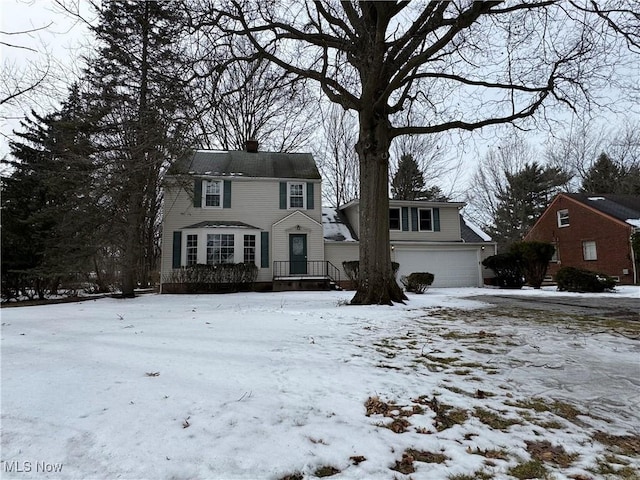 view of front facade with an attached garage and a chimney