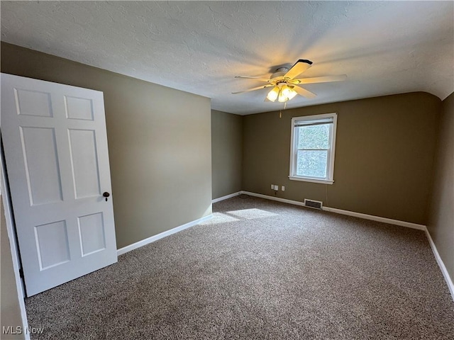 carpeted empty room featuring visible vents, ceiling fan, a textured ceiling, and baseboards