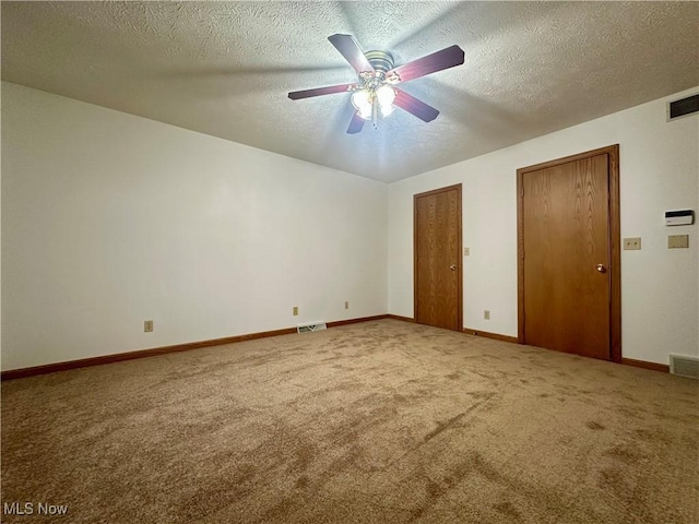 unfurnished bedroom featuring carpet, two closets, and visible vents