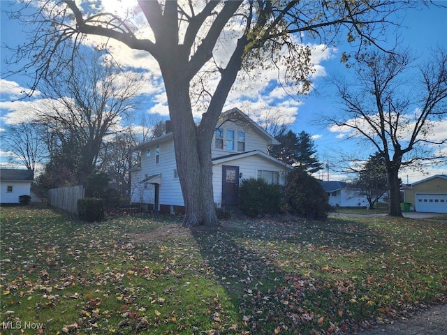 view of property exterior featuring a lawn and fence