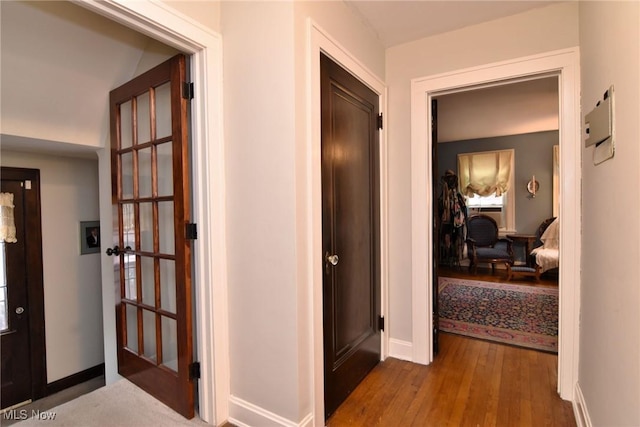 corridor with wood finished floors and baseboards