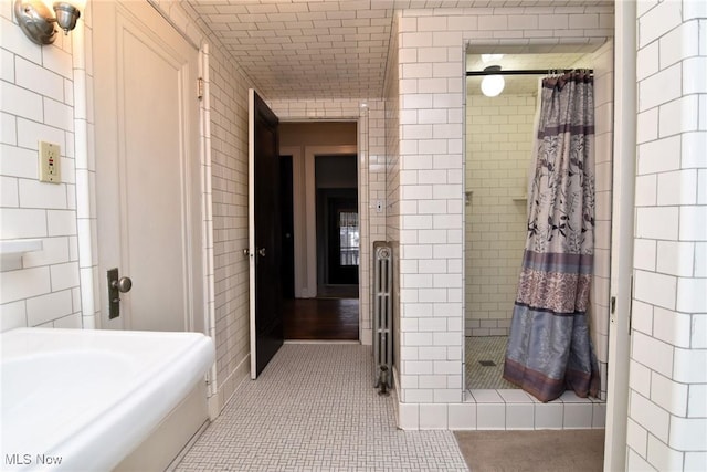 full bath featuring a shower stall, tile walls, and tile patterned floors