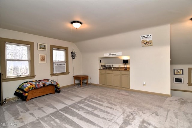 interior space with light carpet, vaulted ceiling, cooling unit, and baseboards