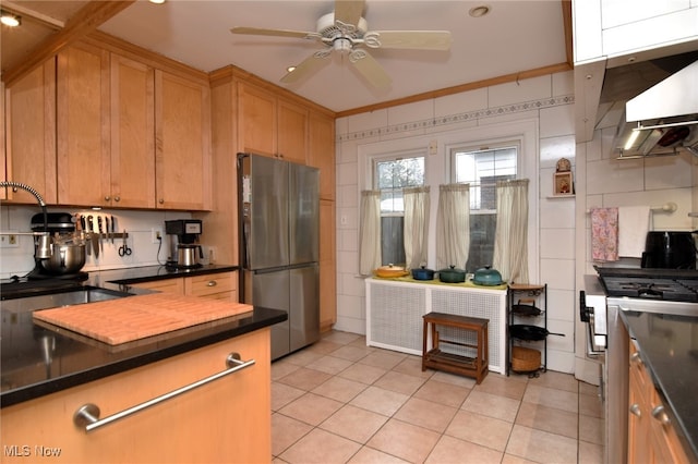 kitchen with light tile patterned floors, appliances with stainless steel finishes, dark countertops, and tile walls