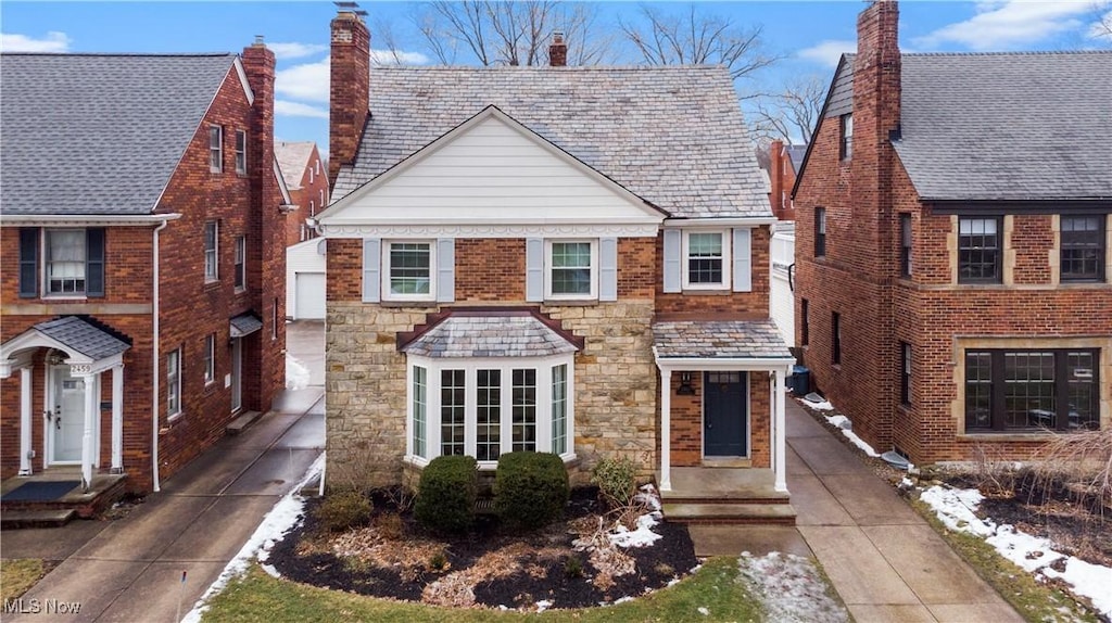 view of front of home featuring a high end roof, brick siding, and driveway