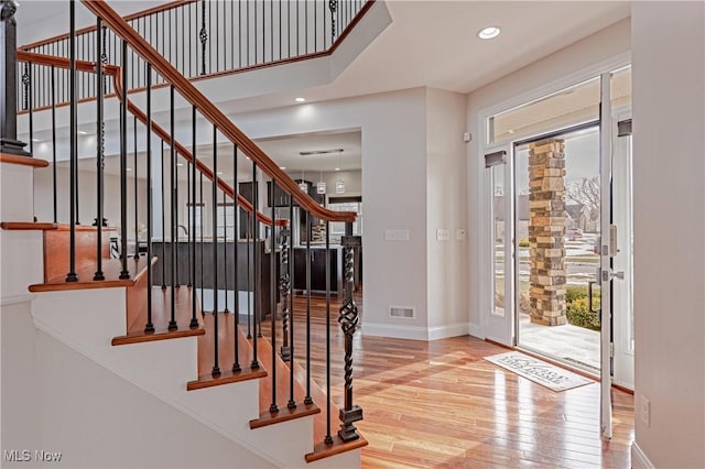 foyer featuring recessed lighting, visible vents, stairway, wood finished floors, and baseboards