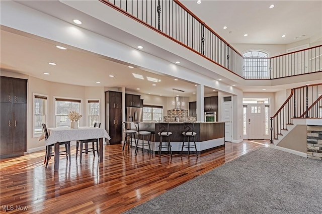 interior space with stairs, recessed lighting, baseboards, and wood finished floors