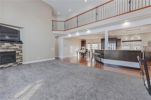 living room with a wealth of natural light, a fireplace, baseboards, and wood finished floors