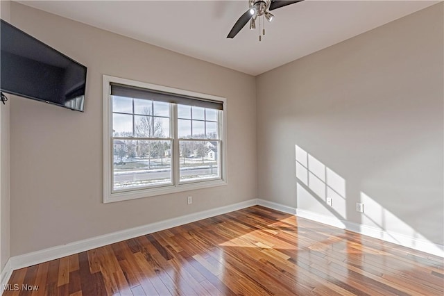 empty room featuring hardwood / wood-style flooring, ceiling fan, and baseboards