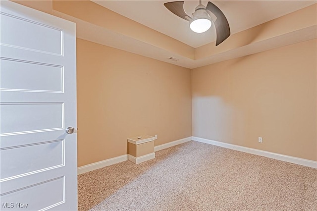 spare room with carpet floors, visible vents, baseboards, and a ceiling fan