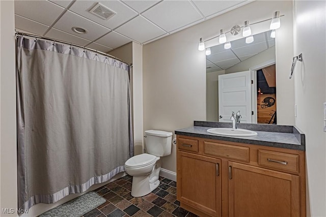 bathroom with toilet, visible vents, a drop ceiling, and vanity