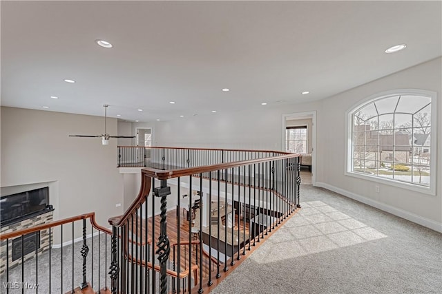 hallway featuring recessed lighting, baseboards, carpet flooring, and an upstairs landing