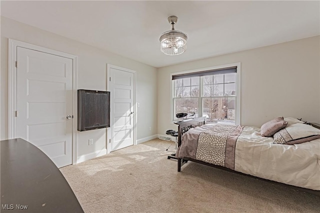 bedroom featuring a chandelier, carpet, and baseboards